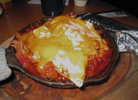 CARNE ADOVADA Skillet filled with delicious carne adovada on top of papitas and two fried huevos.