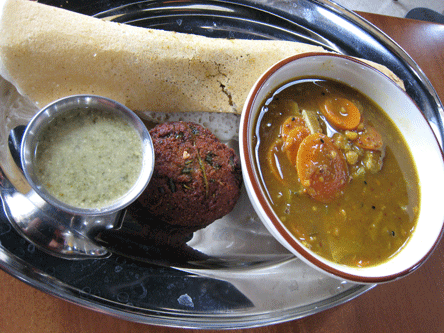 South Indian Sampler Plate: One Miniature Masala Dosa, a piece of Vadai, a bowl of Sambhar with two Idlis and a side of coconut chutney