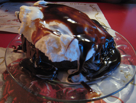 Chocolate Cake topped with ice cream and chocolate fudge