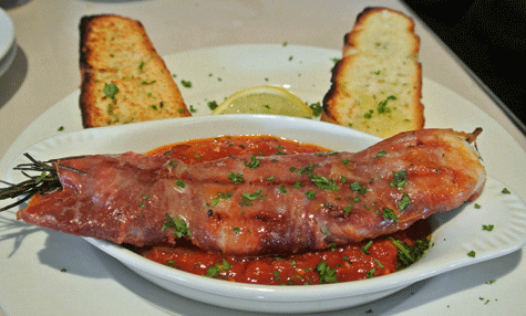 Shrimp wrapped in prosciutto and covered in marinara sauce with crostini