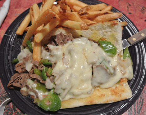 Classic Cheesesteak: Grilled thin sliced steak, onions, bell peppers, mushrooms and chopped green chile on a baguette