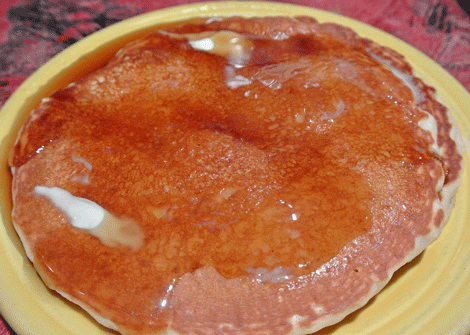 Two pancakes with butter and syrup